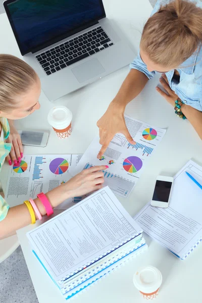 Zwei Frauen, die zusammen im Büro am Schreibtisch sitzen — Stockfoto