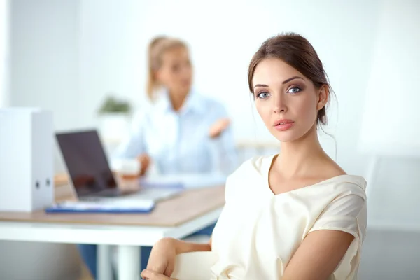 Attractive businesswoman sitting on desk in the office — Stock Photo, Image