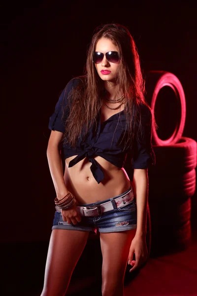 Portrait of young woman standing in the old garage. isolated on black background — Stock Photo, Image