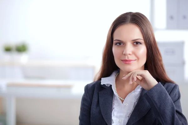 Empresária atraente sentada na mesa no escritório — Fotografia de Stock