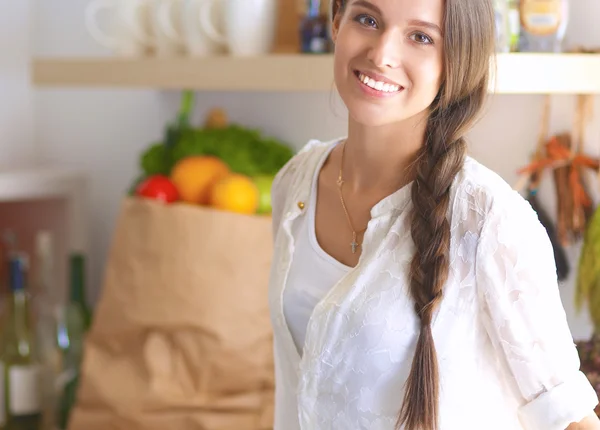 Jeune femme debout près du bureau dans la cuisine — Photo
