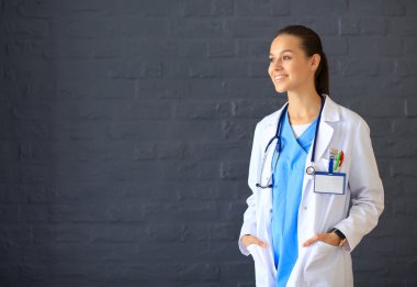 Beyaz önlüklü güzel bir kadın, el ele poz veriyor..