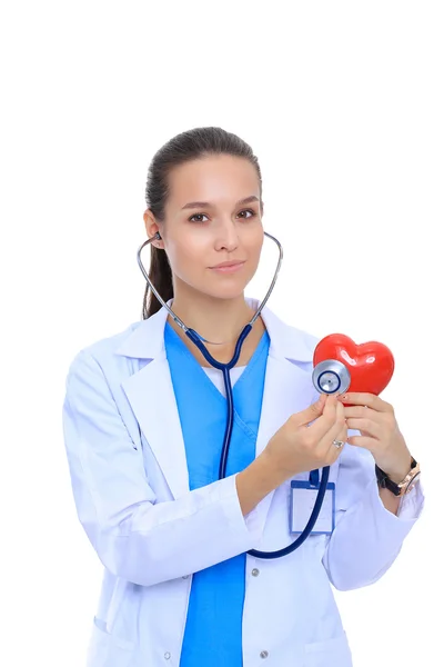 Un médecin avec stéthoscope examinant le cœur rouge, isolé sur blanc — Photo