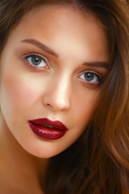 Gri arka planda izole edilmiş güzel bir kadının portresi.