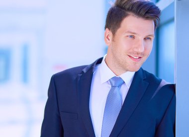 Ofisteki pencerenin yanında duran işadamının portresi