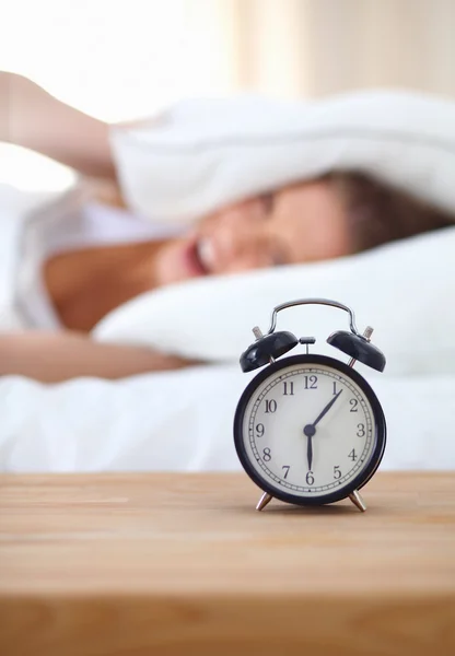 Young sleeping woman and alarm clock in bedroom at home — Stock Photo, Image