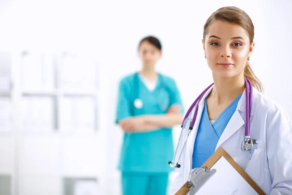 Woman doctor standing with folder at hospital — Stock Photo, Image