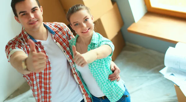 Genç Çift başparmak göstermek yukarıya onların yeni modern tasarım evinde mutlu