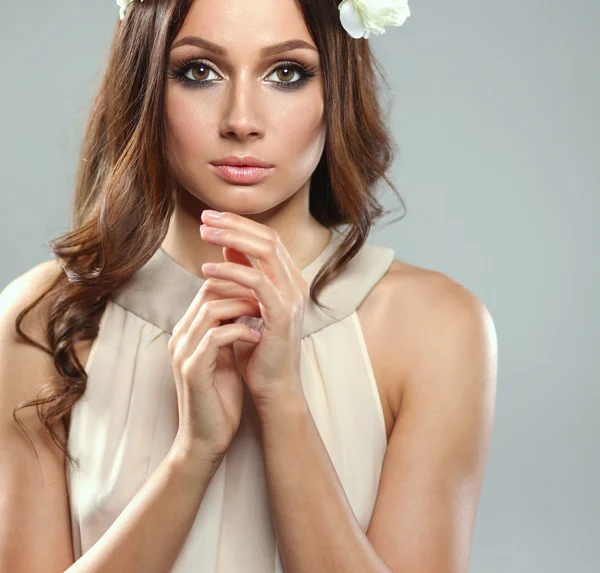 Retrato de uma mulher bonita com flores no cabelo — Fotografia de Stock