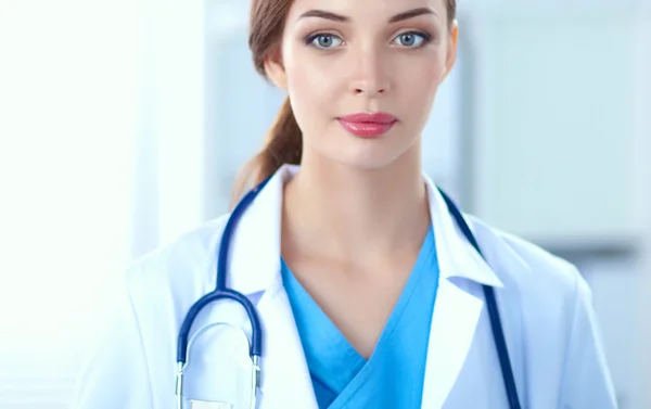 Retrato de una joven doctora con una bata blanca de pie en el hospital —  Fotos de Stock