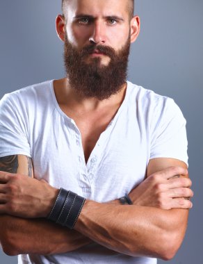 gri arka plan üzerinde izole çapraz kollu yakışıklı sakallı adam portresi