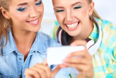 iki kızla birlikte telefon resmi için bakmak