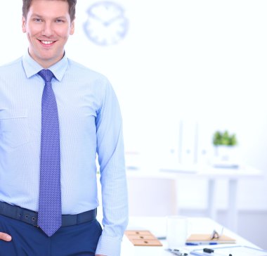 Ofiste masasının karşısında duran bir iş adamı ya da yönetici.