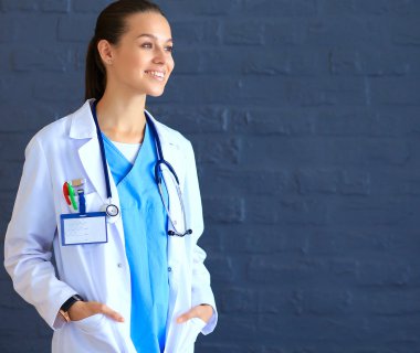 Beyaz önlüklü güzel bir kadın, el ele poz veriyor..