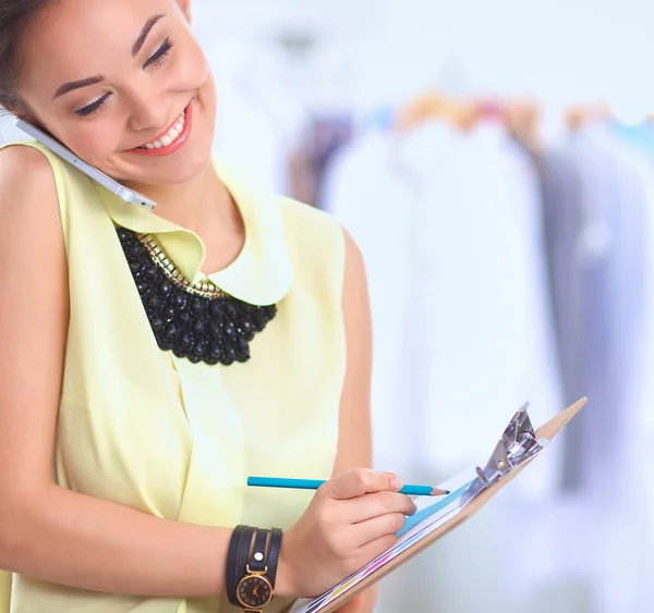 Pretty fashion designer working in office using mobile phone — Stock Photo, Image