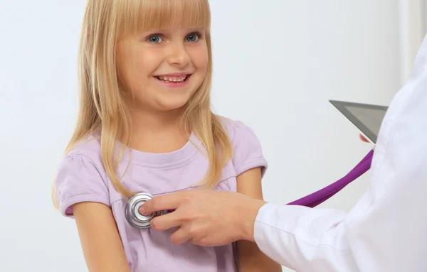 Female doctor examining child with stethoscope at surgery — Stock Photo, Image