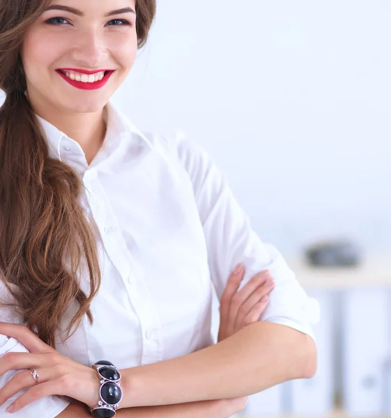 Attractive businesswoman with her arms crossed  standing in office — Stock Photo, Image