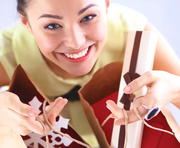 Usmívající se žena s vánoční dárky, izolované na červeném pozadí — Stock fotografie