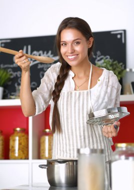 Mutfakta ahşap kaşıkla yemek pişiren kadın