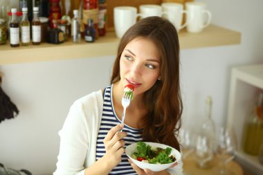 Salata yemek ve karışık salata tutan genç kadın