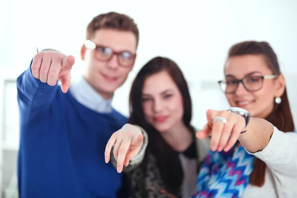 Jeunes gens d'affaires debout au bureau près du bureau et vous montrant du doigt — Photo