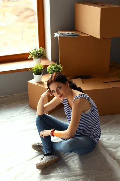 Mujer en un nuevo hogar con cajas de cartón —  Fotos de Stock