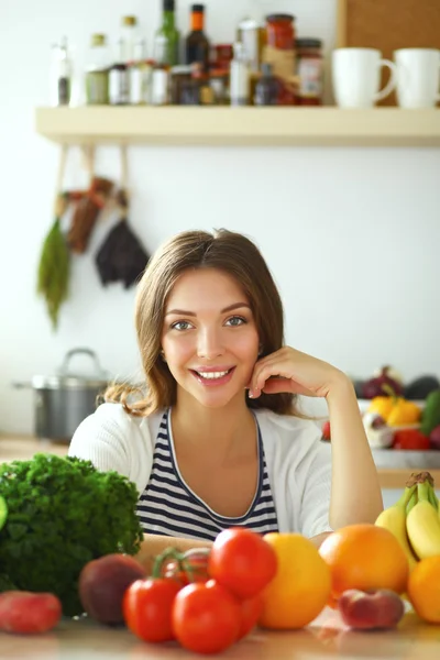 Young woman standing near desk in the kitchen — Stock Photo, Image