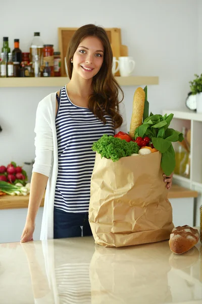 Young woman holding grocery shopping bag with vegetables — Stock Photo, Image