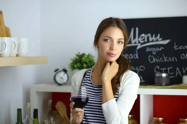 Pretty woman drinking some wine at home in kitchen . — Stock Photo, Image