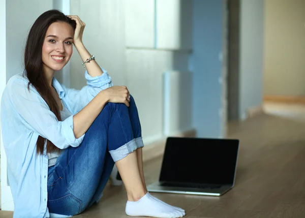 Joven hermosa mujer en casa sentada en el suelo con el ordenador portátil — Foto de Stock