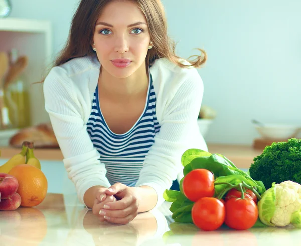 Giovane donna in piedi vicino alla scrivania in cucina — Foto Stock