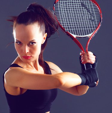 Gri arka plan üzerinde Tenis oynayan kadın