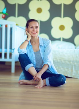 Çocuk karyolası yakın katta oturan genç kadın.