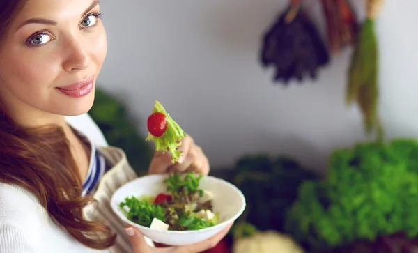 Young woman eating salad and holding a mixed salad — Stock Photo, Image