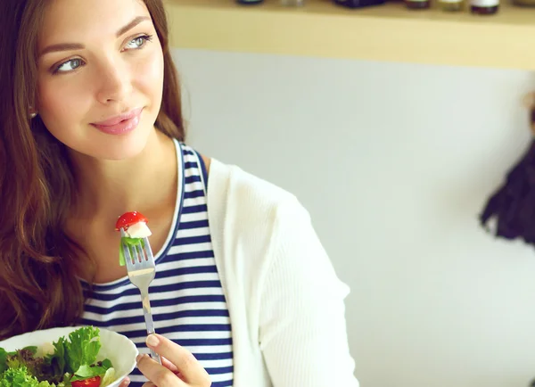 Ung kvinna äta sallad och hålla en blandad sallad — Stockfoto