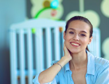 Çocuk karyolası yakın katta oturan genç kadın.