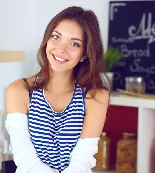 Young woman sitting near desk in the kitchen — Stock Photo, Image