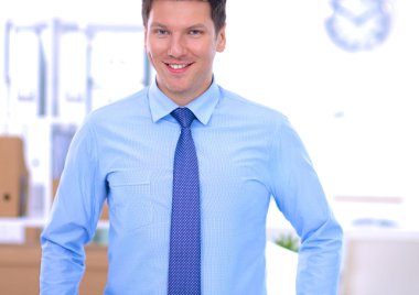 Ofiste masasının karşısında duran bir iş adamı ya da yönetici.