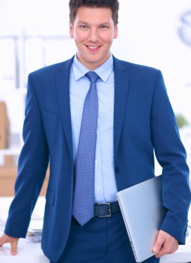 Ofiste masasının karşısında duran bir iş adamı ya da yönetici.