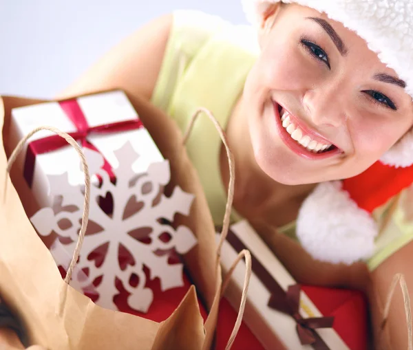 Menina feliz no chapéu de santa segurando um saco de compras com caixa de presente — Fotografia de Stock