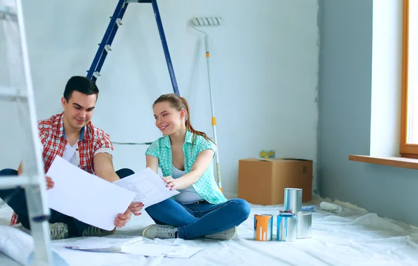 Young couple sitting on floor and calculating about they savings — Stock Photo, Image