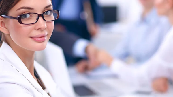 Schöne junge Geschäftsleute mit Kollegen, die im Hintergrund diskutieren — Stockfoto