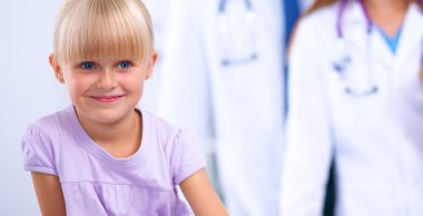 Kadın doktor ameliyatta steteskopla çocuğu muayene ediyor.