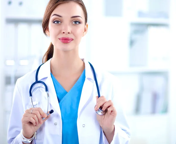 Portrait of young woman doctor with white coat standing in hospital — Stock Photo, Image