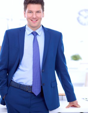 Kendine güvenen başarılı genç işadamı eğilimli silah masasının üzerindeki