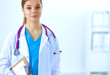 Kadın doktor hastanede dosyayla bekliyor.