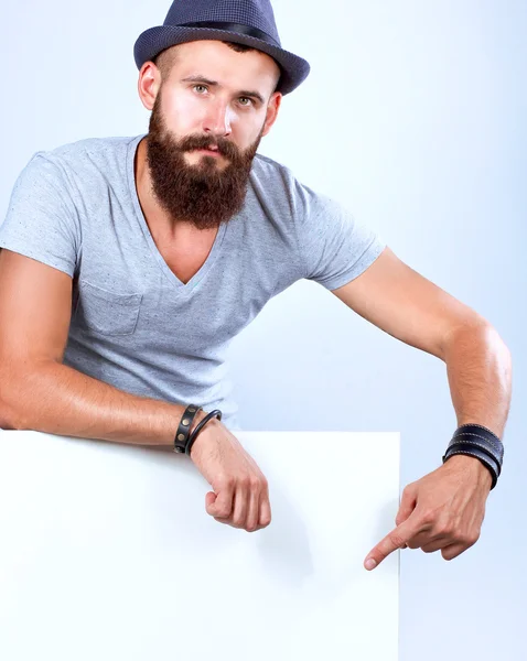 Portrait of young man in hat standing near blank, isolated on white background — Stock Photo, Image