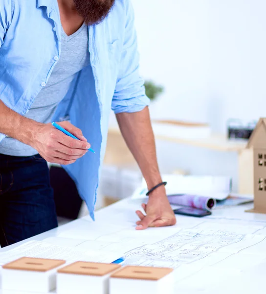 Portrait of male designer in hat with blueprints at desk — Stock Photo, Image