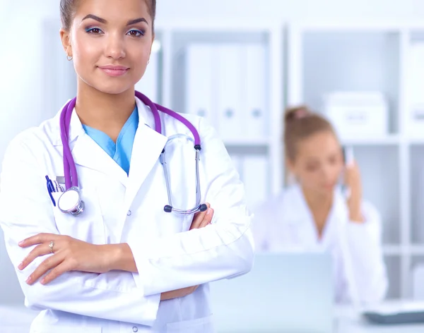 Portret de femeie tânără doctor cu haină albă în picioare în spital — Fotografie, imagine de stoc
