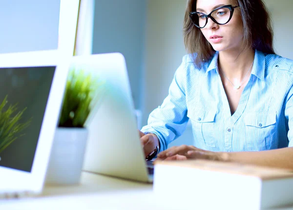 Ofis masasında oturan genç bir kadın dizüstü bilgisayar ekranına bakıyor. . — Stok fotoğraf